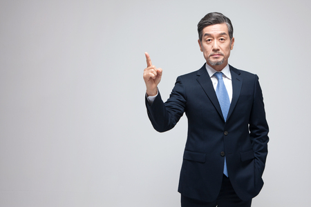 Asian man pointing isolated on whiteの写真素材