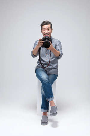 Asian man photographer with camera isolated on whiteの写真素材
