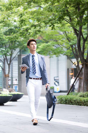 Asian young man walking on the streetの写真素材