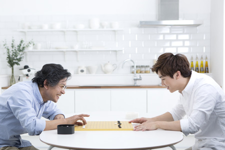 Asian father and son playing chess