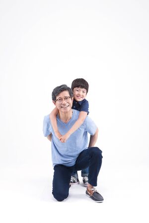 Asian grandfather and grandson looking happy isolated on whiteの写真素材