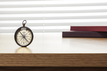 A compass isolated on a brown tableの写真素材