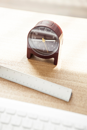 A brown table clock isolated on a brown tableの写真素材