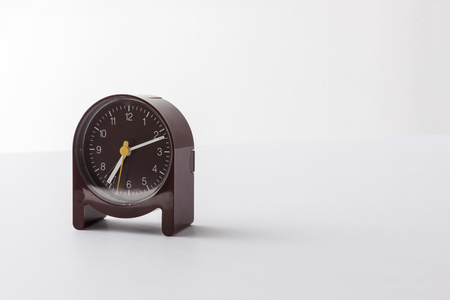 A brown table clock isolated on white backgroundの写真素材