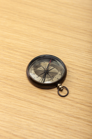 A compass isolated on a brown tableの写真素材