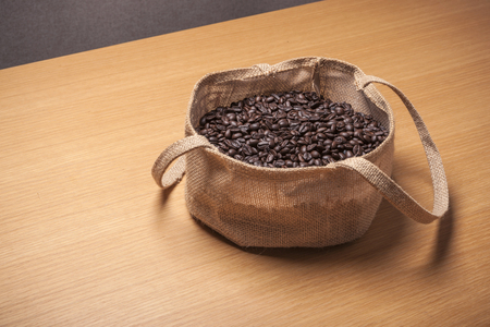Coffee beans in a bag isolated on brown backgroundの写真素材