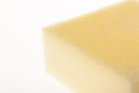 A yellow sponge isolated on white backgroundの写真素材