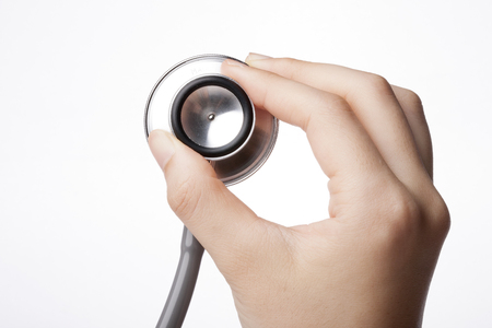 A stethoscope isolated on white background held by a right handの写真素材