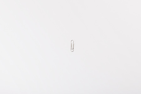 A grey paper clip isolated on white backgroundの写真素材
