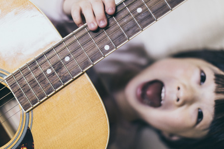 happy smile young boy and the guitarの写真素材