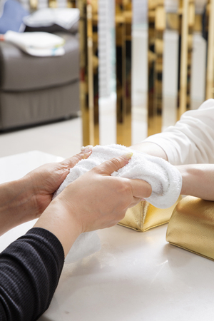 Nail salon woman hands treatment. Nail saloon woman painting color nail polish in hands stock photo. 044の写真素材