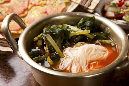 Spicy and cold Korean noodles with kimchi in a steel container, close-up shotの写真素材
