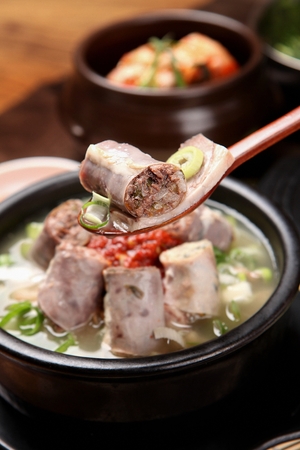 Close-up shot of scooped Korean sausage and rice from soup pot, gukbapの写真素材