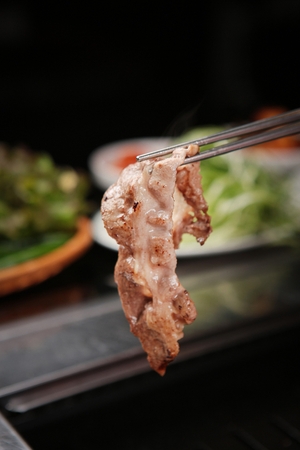 Korean barbecue, assorted beef parts held using chopsticksの写真素材