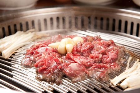 Korean Eonyang-style Bulgogi, barbecued beef with garlic and mushrooms on grillの写真素材