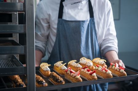 Long cream cake with toppings on topの写真素材