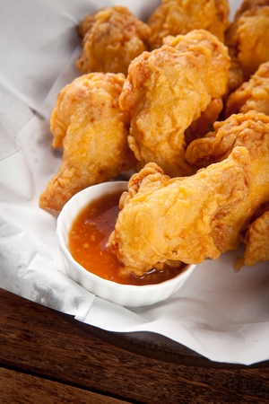 close-up shot of fried chicken bite dipped in soy garlic sauceの写真素材