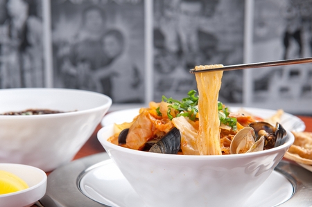 Chinese style noodles with vegetables and spicy soup and seafood