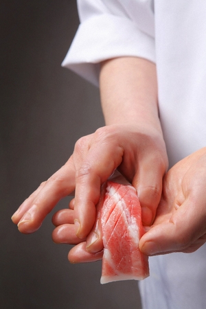sushi chef making tuna sushi, close-up shotの写真素材