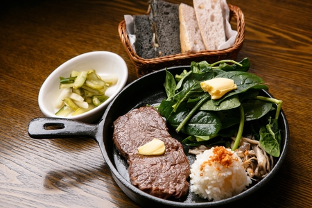 beef steak served with salad, garlic rice, pickles and breadsの写真素材