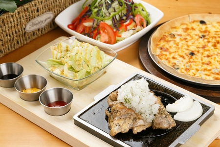 pork steak served with salads and cheese pizzaの写真素材