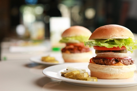 Handmade burgers on two white platesの写真素材