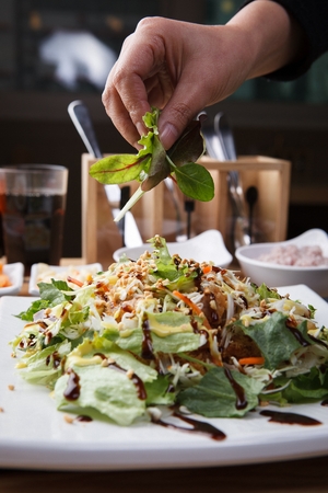 salad with various vegetables, held with hand, close-up shotの写真素材
