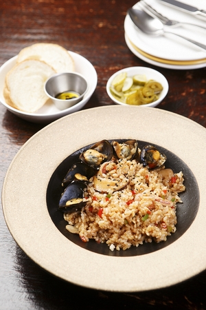 Seafood pilaf with mussels on a wooden tableの写真素材