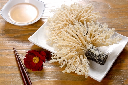 Deep fried glass noodles in seaweed, on a plate, on a wooden tableの写真素材
