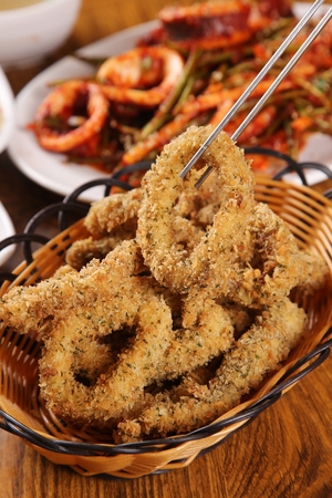Fried squid in a basket, on a wooden tableの写真素材