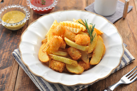 French fries on a round plate, on a wooden tableの写真素材