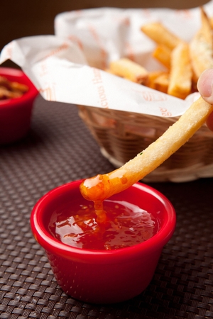 French fries in sauce, on a basket, on a tableの写真素材
