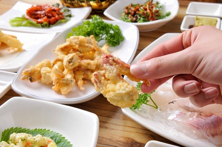 Deep-fried crab and side dishes on a plate, on a wooden tableの写真素材