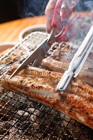 Eels being grilled on charcoalの写真素材