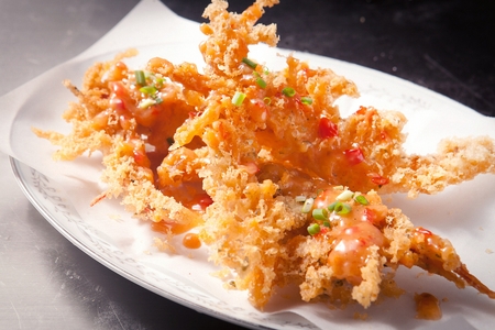 Fried shrimp and sauce on a plate, on a wooden tableの写真素材