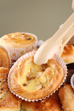 Pincers picking up almond bread in bakeryの写真素材