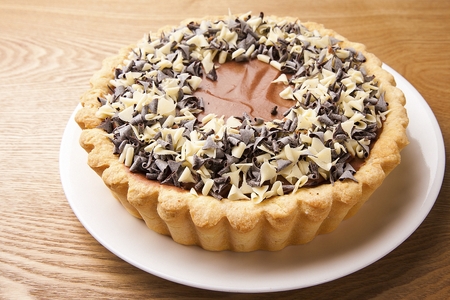 Tart with sprinkled chocolate powder on white plateの写真素材
