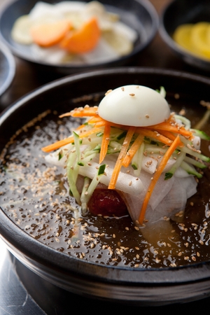famous Korean cuisine, Mul Naengmyeon, buckwheat noodles served in chilled soup made of dongchimi (radish kimchi) and beef brothの写真素材