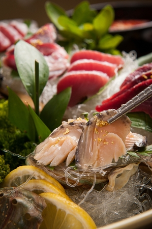 Chopsticks grabbing abalone with gold dustの写真素材