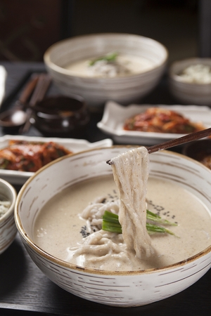 Chopsticks grabbing ddeulggae kalguksu, noodles with grated perilla seeds in brothの写真素材