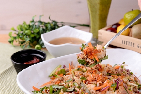 Spoonful of tuna bibimbap, a Korean cuisine, tuna and thinly sliced vegetables mixed with spicy...