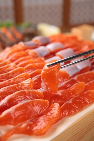 Chopsticks grabbing sliced raw troutの写真素材