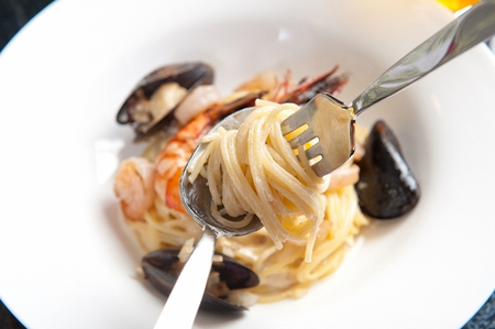 Cream pasta, Western noodle dish made of cream sauce, rolled on spoon using a forkの写真素材