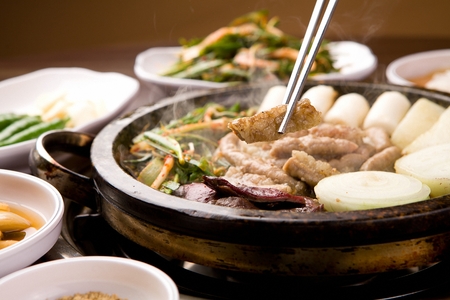 Beef makchang, potatoes, chives being grilled, on a black grillの写真素材