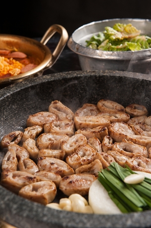 Pork makchang, onions, garlic, chives being grilled on a black grillの写真素材