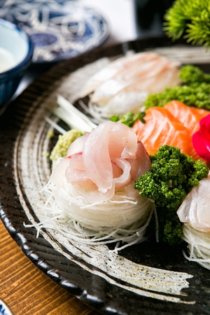 Salmon sashimi, rockfish sashimi, tuna sashimi, on a round dishの写真素材