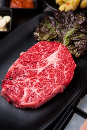 Beef thick skirt, lettuce, on a black plateの写真素材