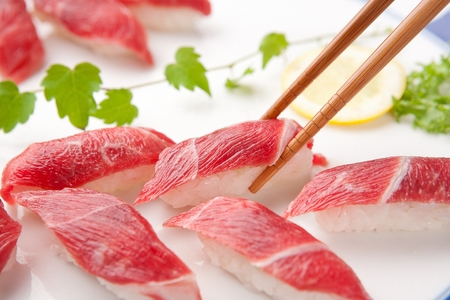Chopsticks grabbing beef sushi, a Japanese cuisineの写真素材