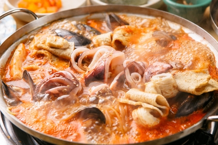 Seafood tteokboki, a Korean cuisine, rice cake, fish cakes, and seafood stir-fried with spicy sauce, boiling in a potの写真素材