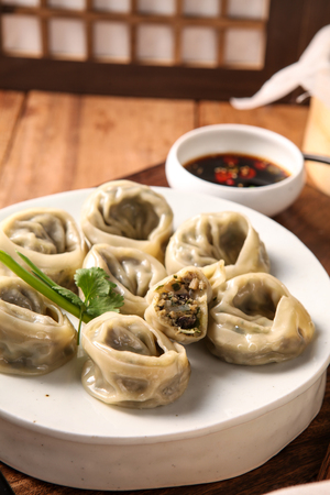 Meat dumplings and soy sauce, on a white round plateの写真素材